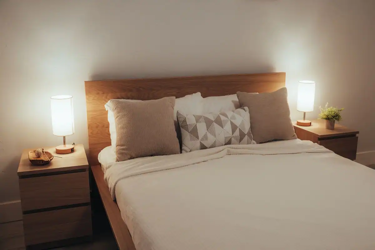 Dormitor minimalist cu lumină blândă și așternuturi moi, potrivit pentru relaxare