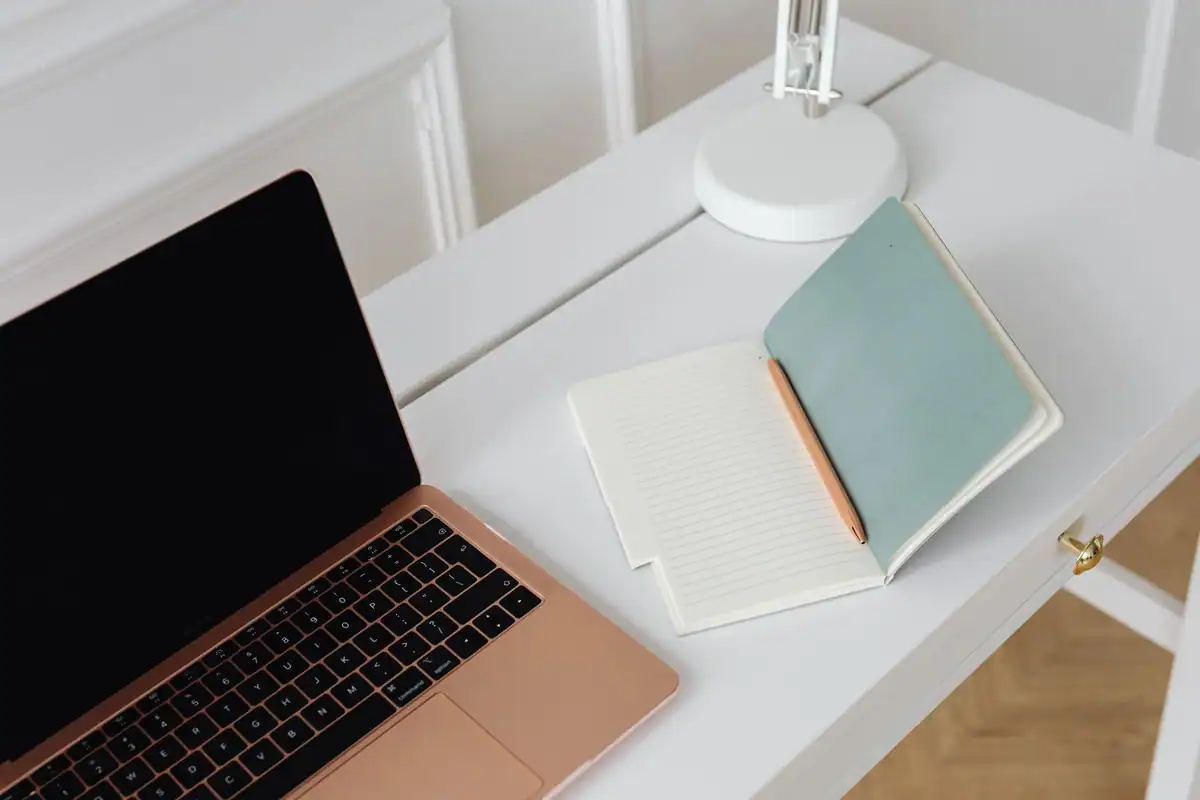 Birou alb curat și minimalist cu un laptop, după încheierea zilei de lucru