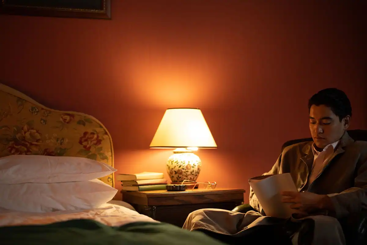 Bărbat care citește seara într-o cameră caldă, în lumină ambientală blândă