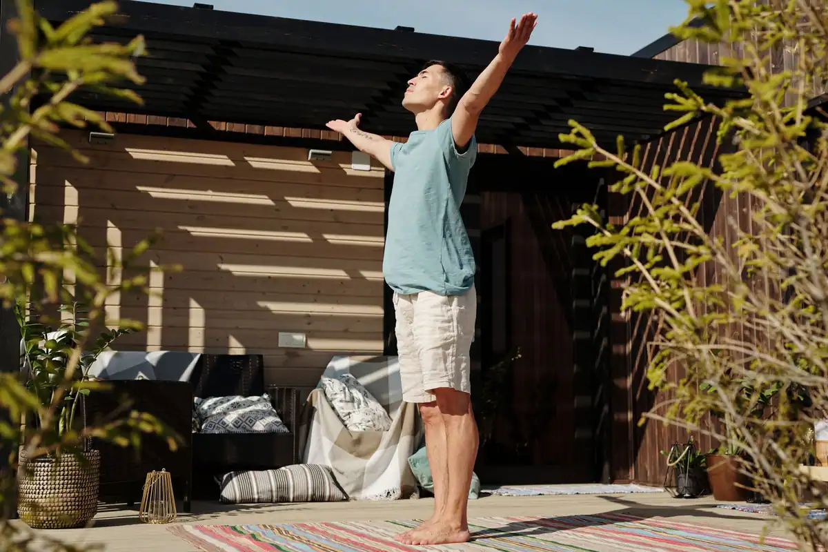 Bărbat care practică yoga pe o verandă însorită, la începutul zilei
