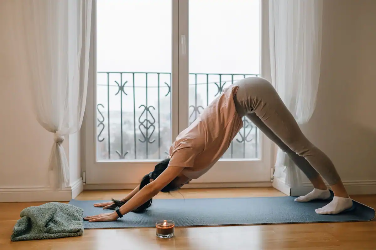 Femeie care face yoga în interior, concentrată pe mișcare și respirație