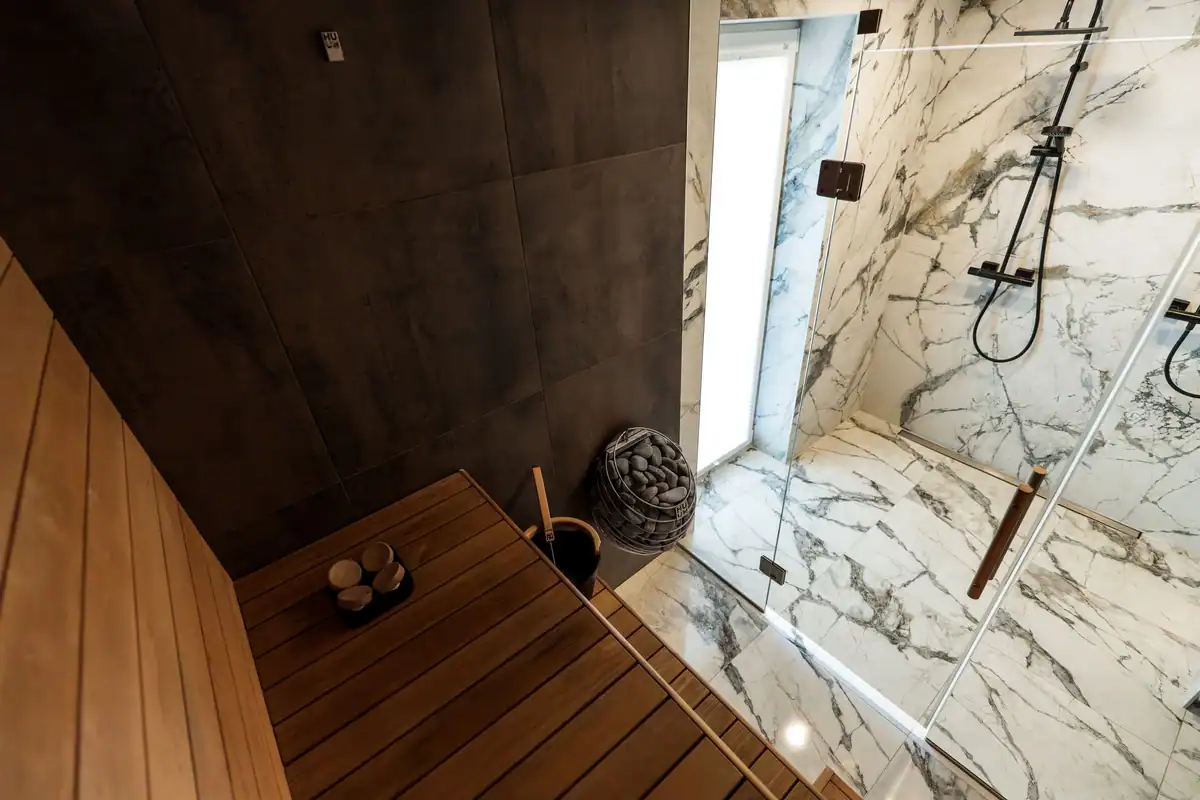 Saună modernă cu design simplu, alături de un duș cu pereți de marmură